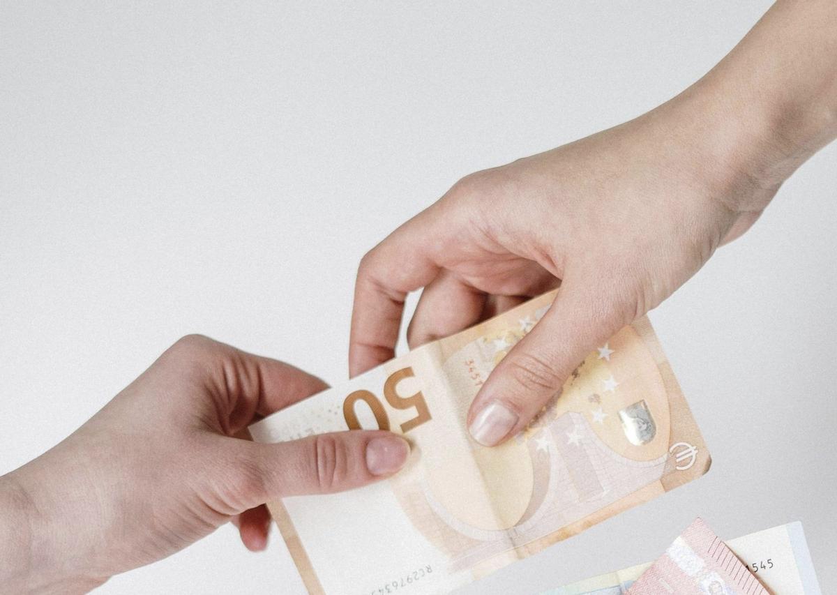 Una persona entrega dinero a otra.