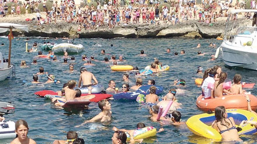 Los nadadores aguardaban los regalos lanzados desde la barca municipal.