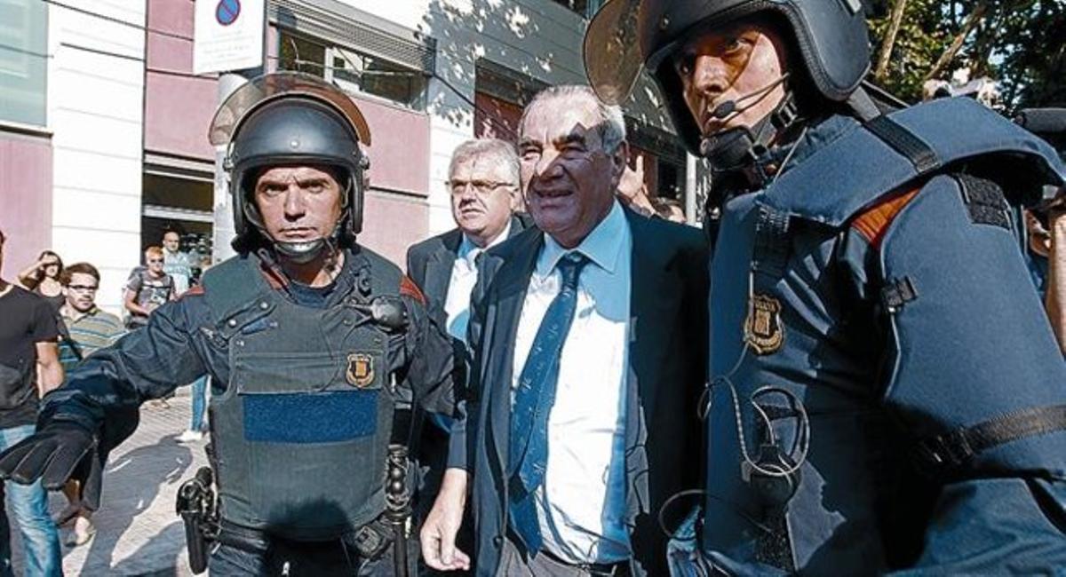 INSULTAT I SACSEJAT 3 L’exconseller Ernest Maragall és acompanyat per diversos agents després de ser assetjat per un grup d’indignats, ahir, al parc de la Ciutadella, abans d’entrar a la Cambra catalana.