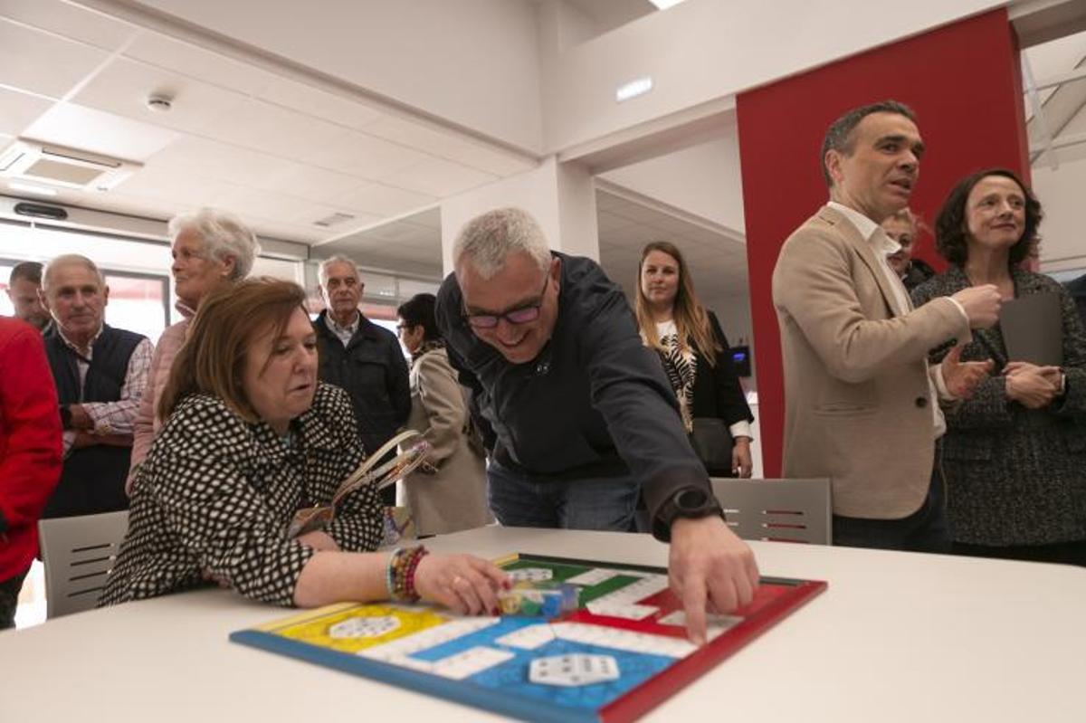 Dos de las personas asistentes a la inauguración comprueban si todo está en orden en un juego de parchís. | María Fuentes