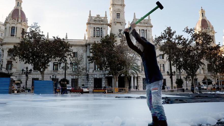 Un operario rompe el hielo a mazazos.