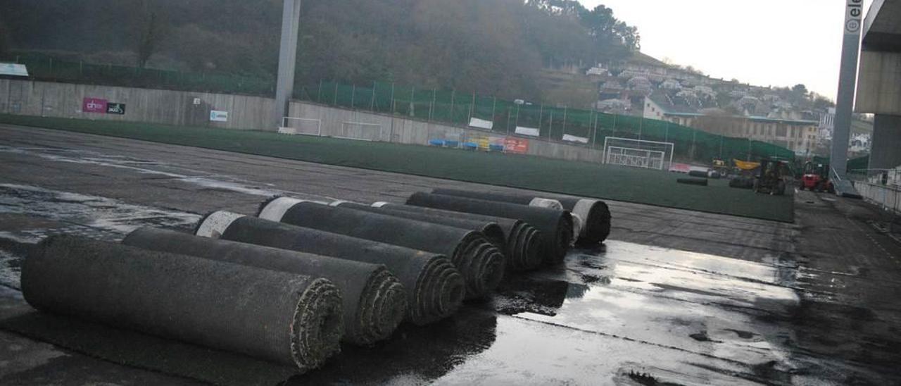 Rollos de césped artificial levantados en el campo de fútbol de El Bayu.