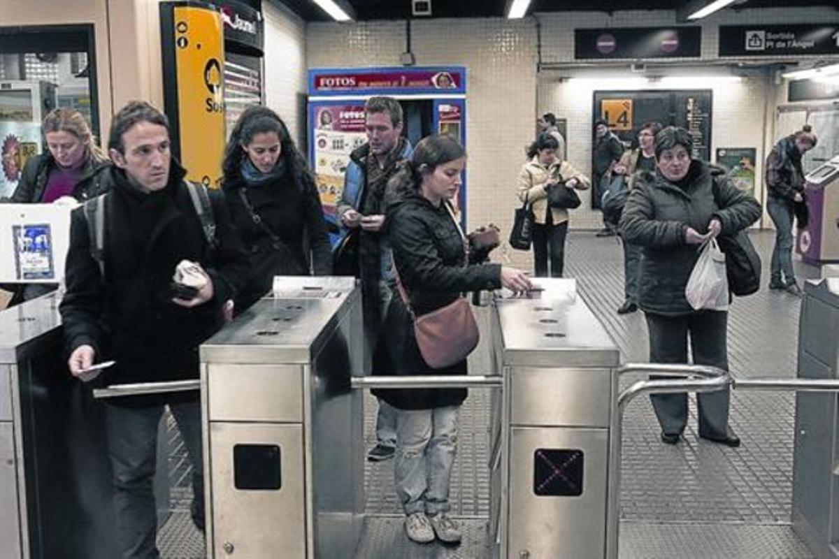 Alguns usuaris entren en una estació del metro de Barcelona validant els seus bitllets. Alguns usuaris entren en una estació del metro de Barcelona validant els seus bitllets.