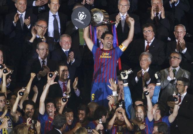Barcelonas Xavi lifts up the Spanish Kings Cup trophy after winning their final soccer match against Athletic Bilbao in Madrid
