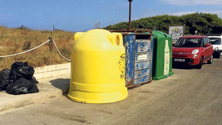 Imagen de algunos contenedores en mal estado y de varias bolsas de basura depositadas en la acera.