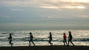 Gente practicando deporte en la playa de Barcelona. 