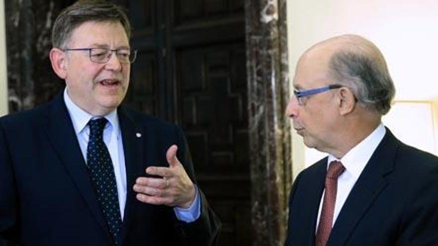 El presidente Puig y el ministro Montoro se saludan antes del encuentro, ayer en Madrid. Foto: Levante-EMV