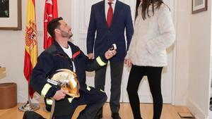 El nuevo bombero, en el momento de pedir la mano de su novia, delante del presidente madrileño, Angel Garrido.
