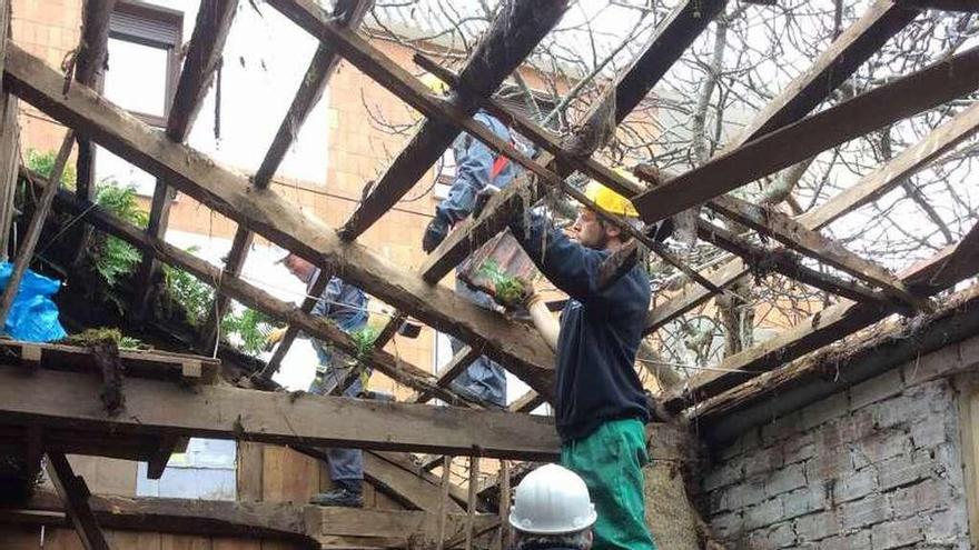 Operarios retirando ayer las tejas de la antigua cubierta. // G.Núñez