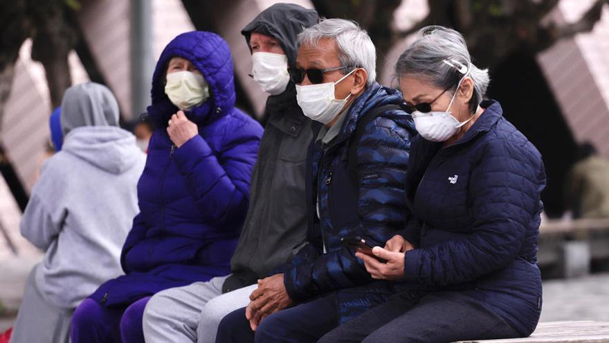 Ciudadanos chinos con las mascarillas para prevenir el contagio