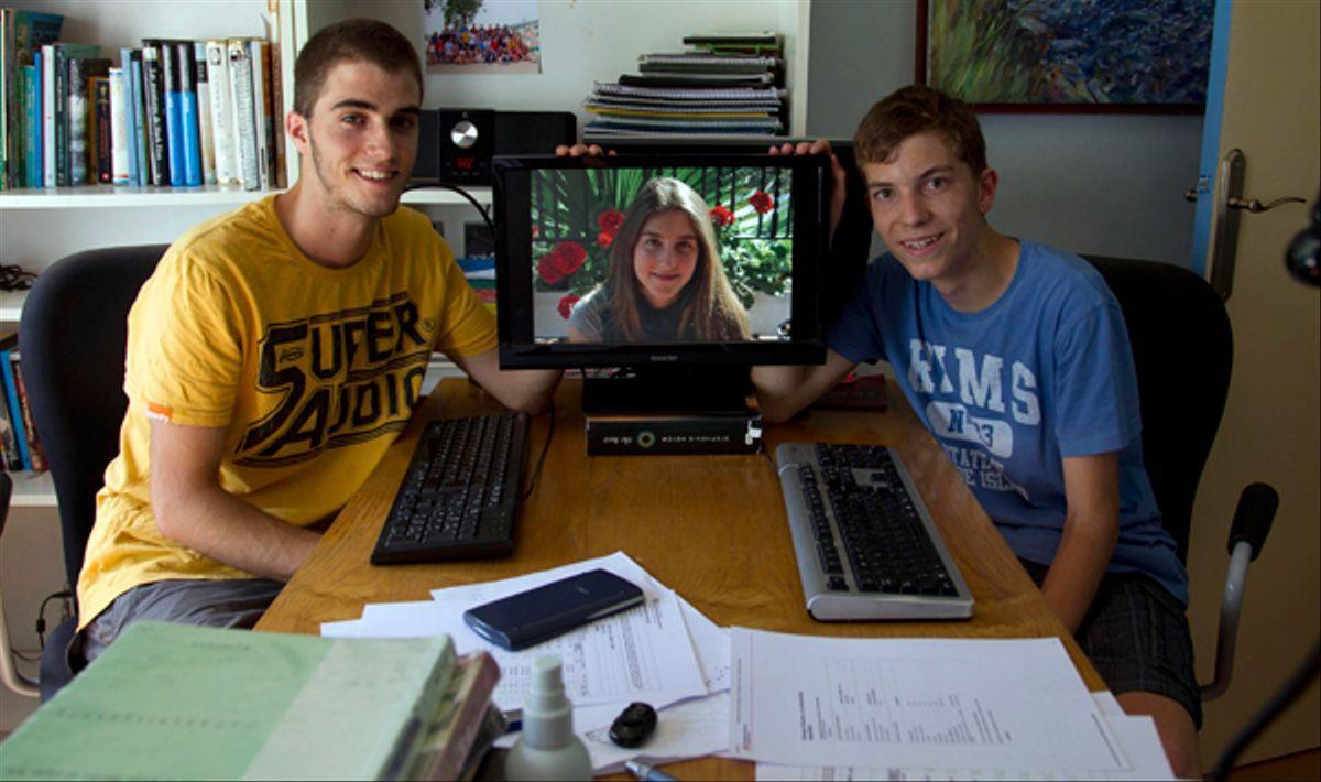 Dídac y Martí Surís Coll-Vinent junto a su hermana Alba, en la pantalla, en junio de 2012.