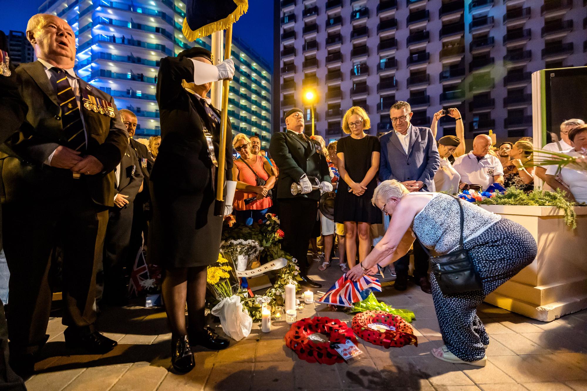 Británicos residentes y turistas de Benidorm rinden un sentido homenaje a Elizabeth II en el espacio habilitado por el Ayuntamiento en la zona inglesa de la ciudad.