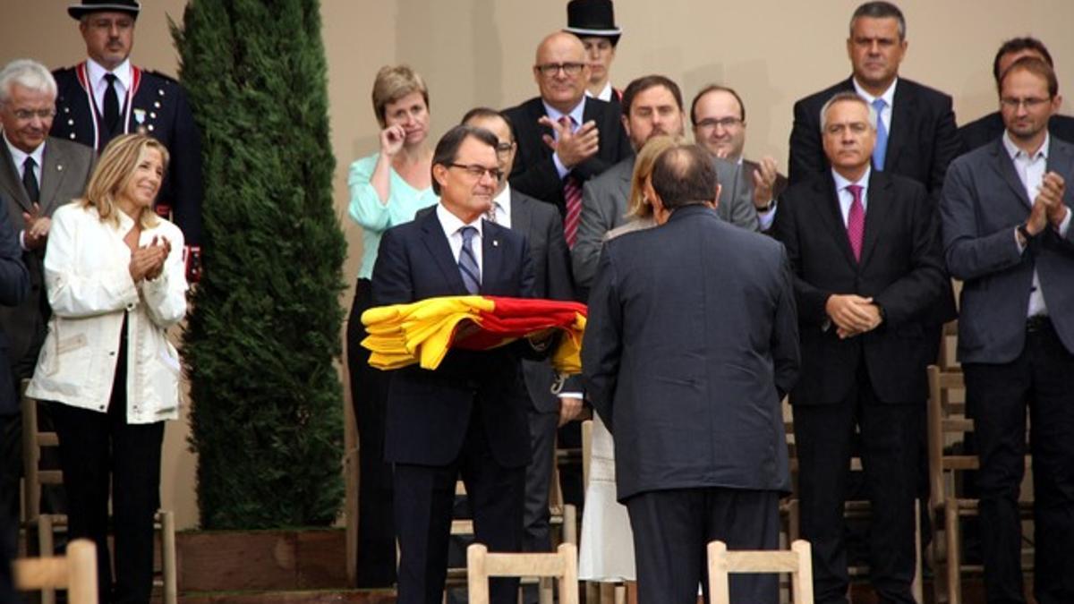 El alcalde de Arenys de Mar entrega una 'senyera' al 'president', en el acto institucional en el Parlament.