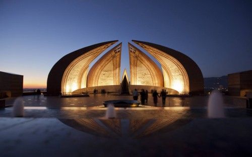 People walk past the Pakistan Monument at sunset in Islamabad