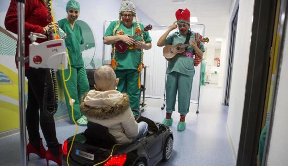 Dos payasos reciben a una niña a las puertas del quirófano del Hospital General.