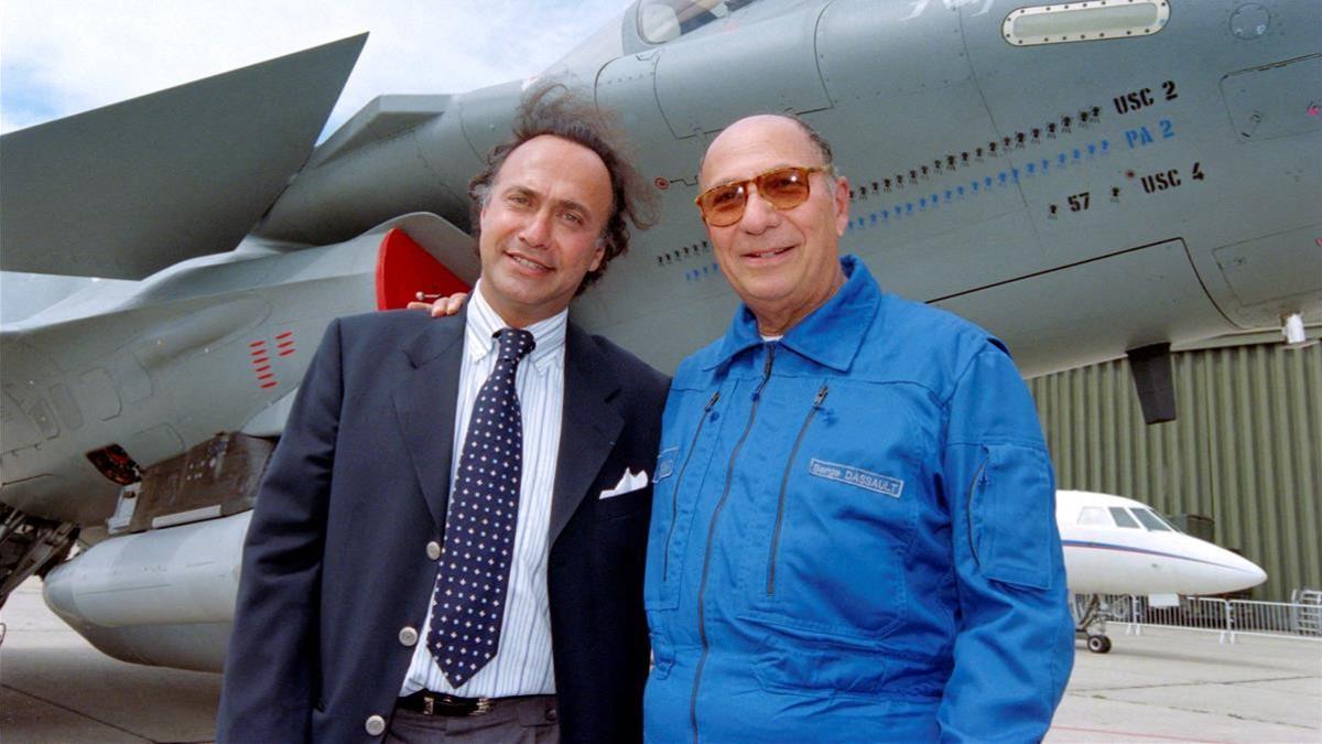 (FILES) In this file photo taken on June 11  1997 Serge Dassault (R)  Dassault Group CEO  poses with his son Olivier Dassault in front of a Rafale M01 jet fighter in Le Bourget  near Paris  - Olivier Dassault has died in the crash of his helicopter near Deauville  a parlamentiary source said on March 7  2021  (Photo by Jack GUEZ   AFP)