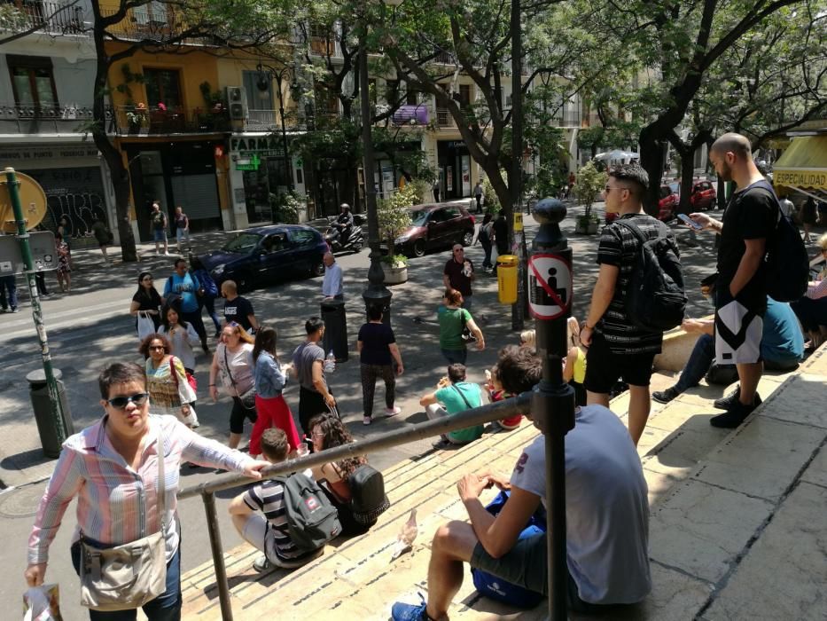 Turistas y usuarios sentados en la escalera del Mercat