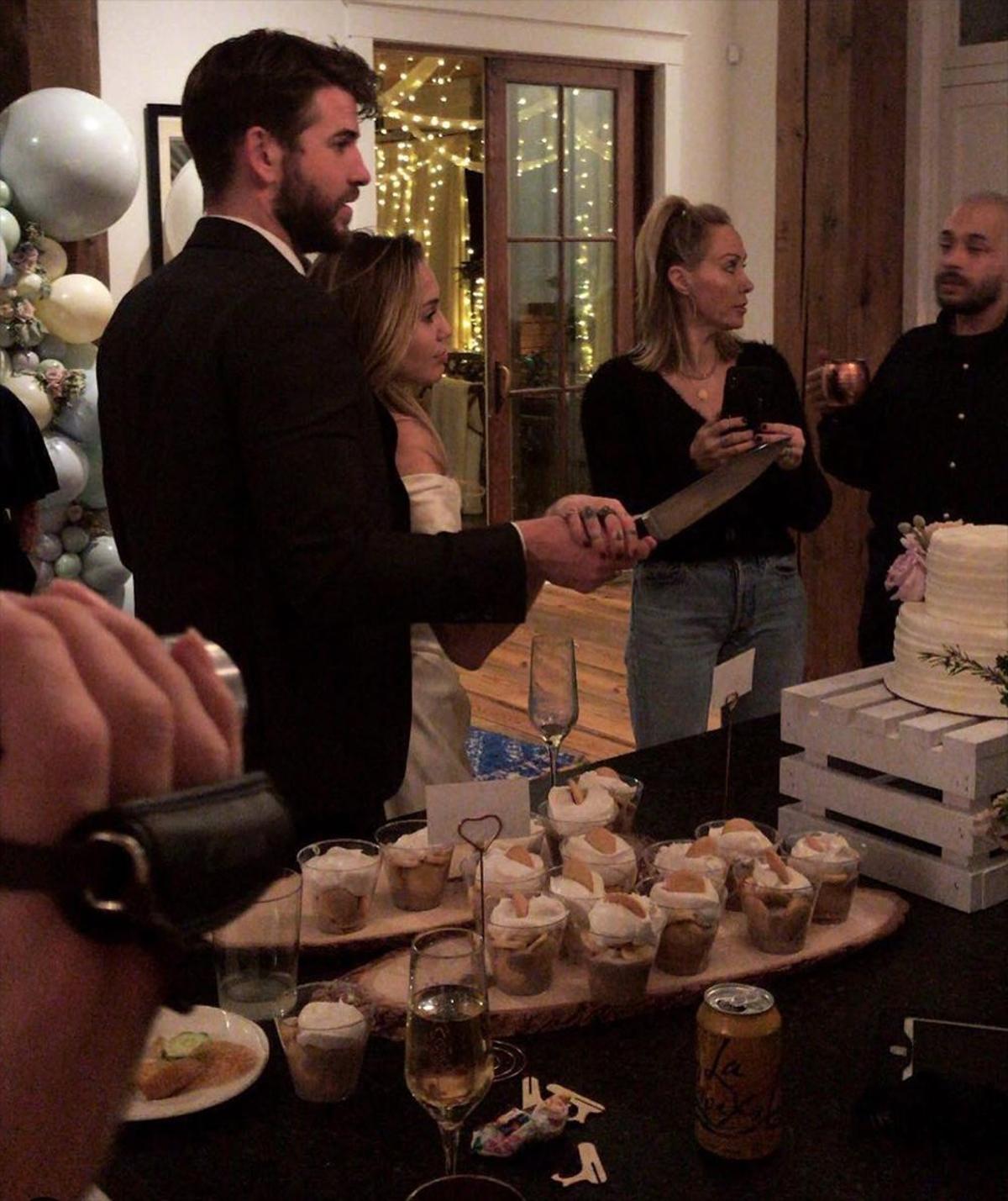 Miley y Liam cortando la tarta