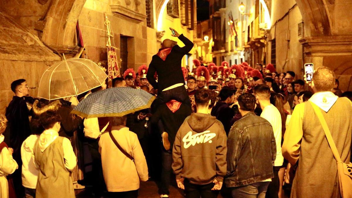 Lorquinos se resguardan de la lluvia que amenazaba la procesión del Domingo de Ramos.