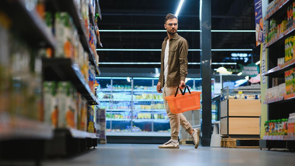 Un joven hace la compra en un supermercado.