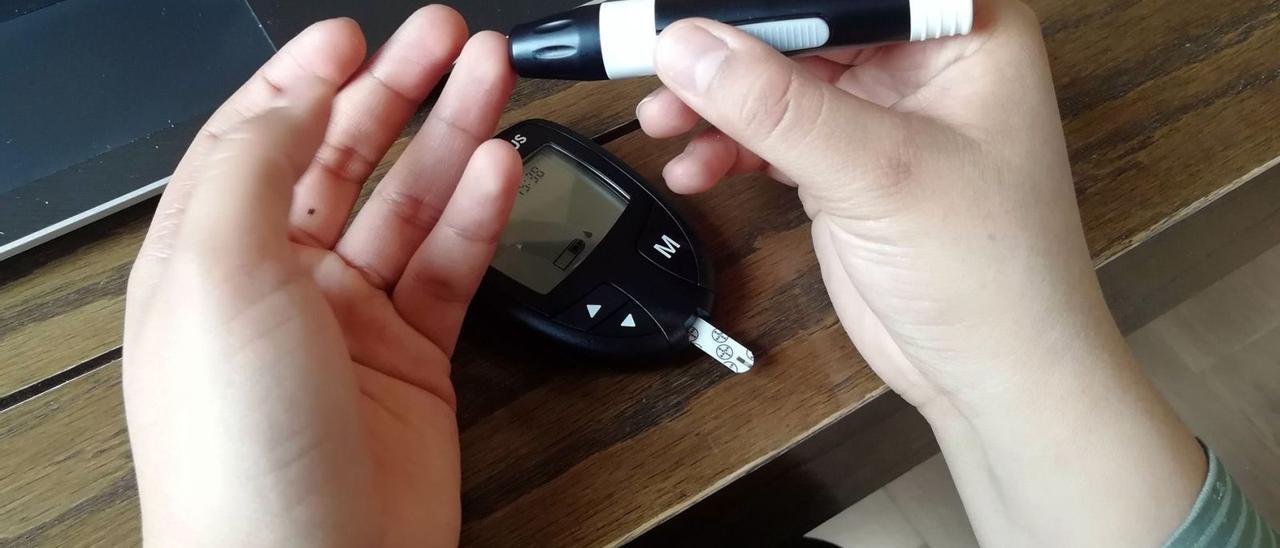 Un niño se mide la cantidad de glucosa en sangre con un dispositivo de medición.