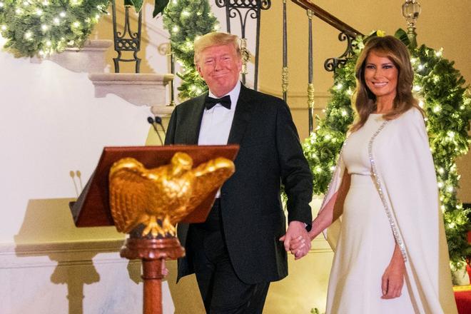 Melania Trump con vestido blanco junto a Donald Trump con esmoquin