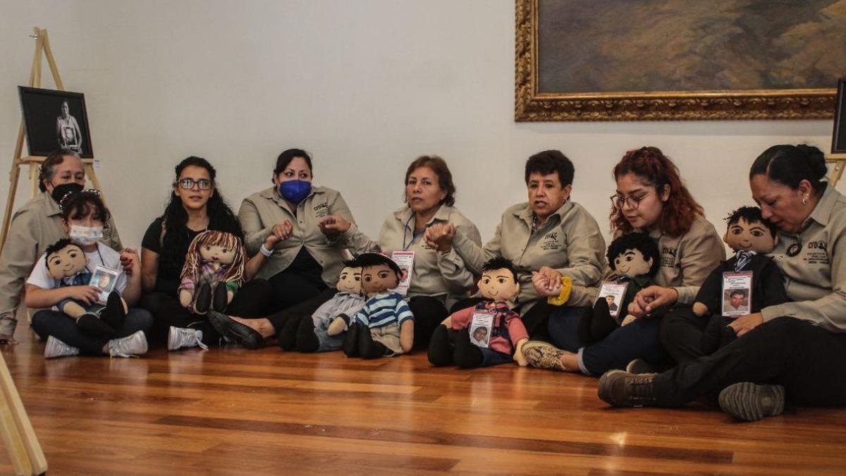 Integrantes del colectivo Familias de Desaparecidos Orizaba-Córdoba con sus muñecos sanadores durante una exposición fotográfica sobre desapariciones, en Ciudad de México.