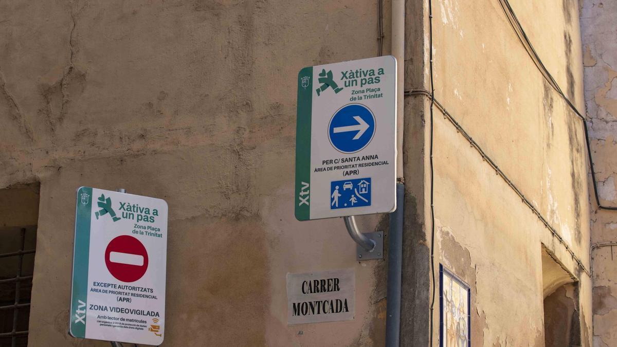 Las señales de la iniciativa "Xàtiva a un pas" atornilladas a la fachada de Santa Clara.