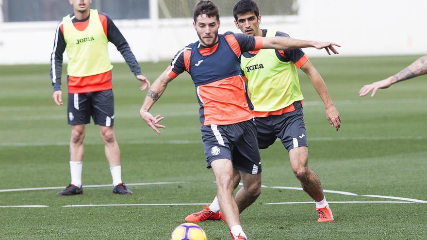 Miguelón controla el esférico ante la mirada de Gerard Moreno.