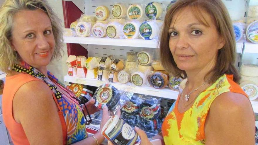 A la izquierda, Juani Frías y Rosa Povedano comprando queso de Cabrales, ayer. Junto a estas líneas, Tamara Martínez con una pieza de queso.