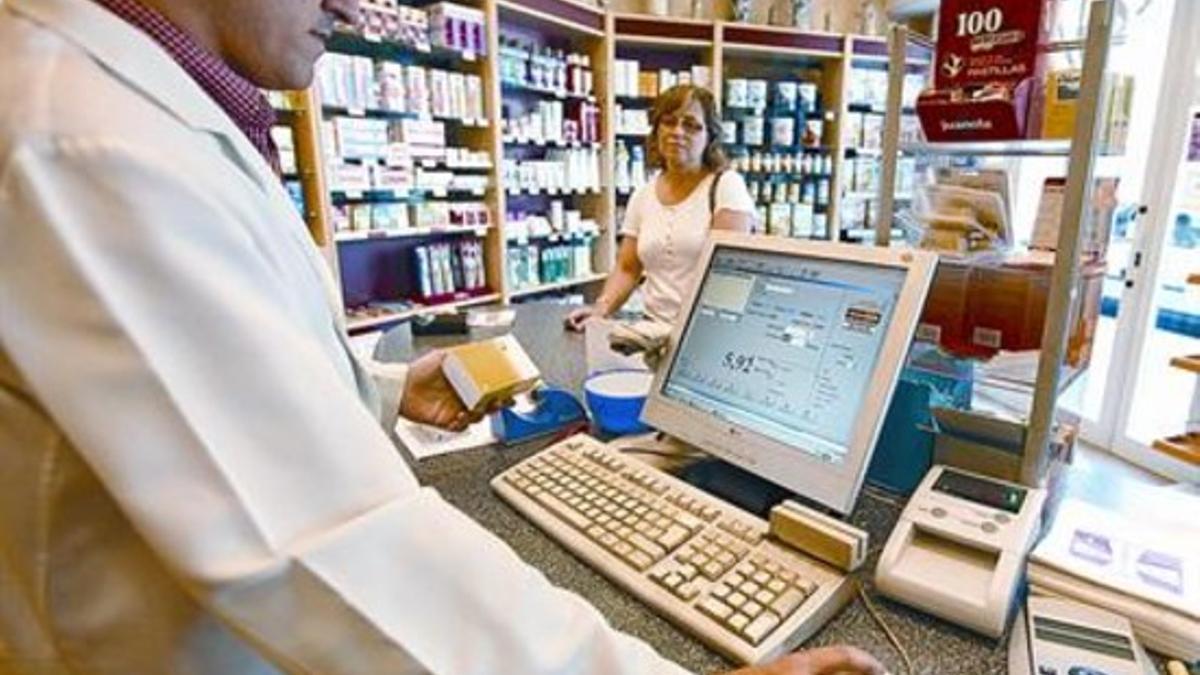 Un farmacéutico atiende a una clienta, en Barcelona, ayer.