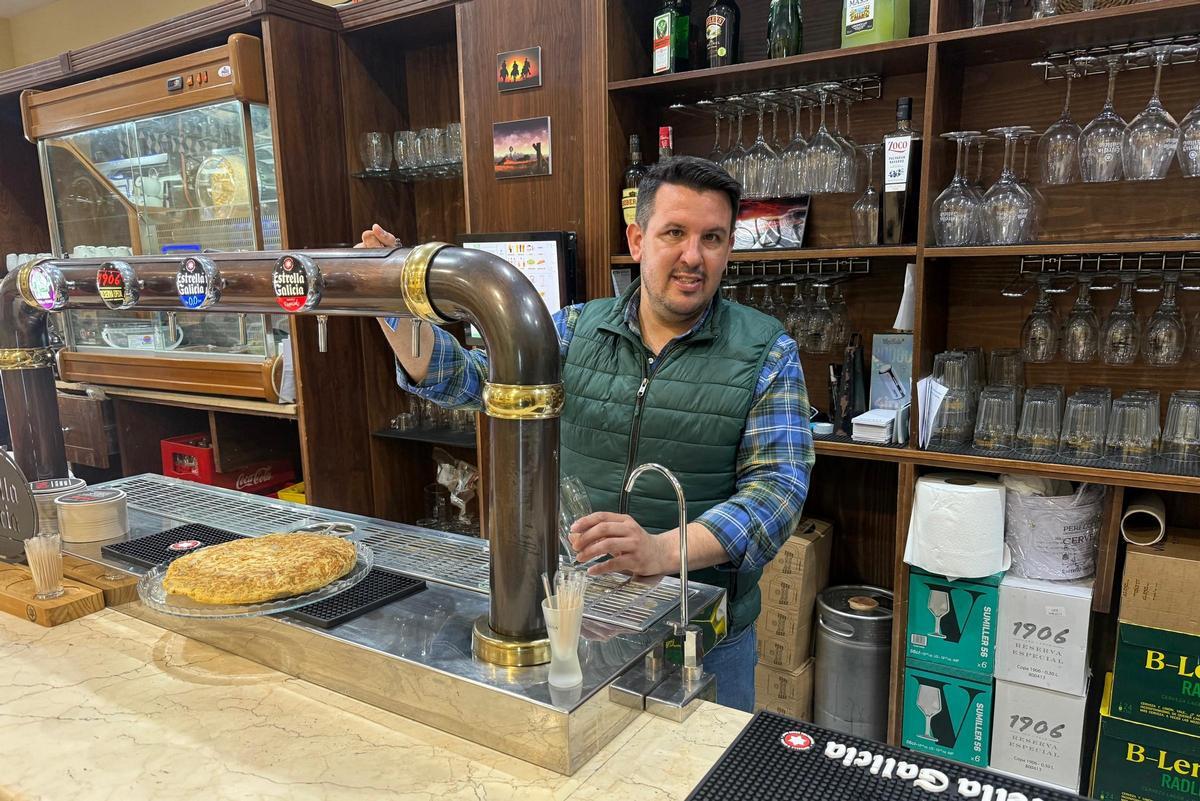 Juan Francisco Rando, al frente del nuevo bar El Rancho, en la barra del establecimiento con una de las tortillas de la casa.