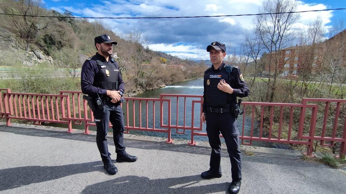 Los dos policías nacionales en el puente sobre el río Nalón en Ciaño