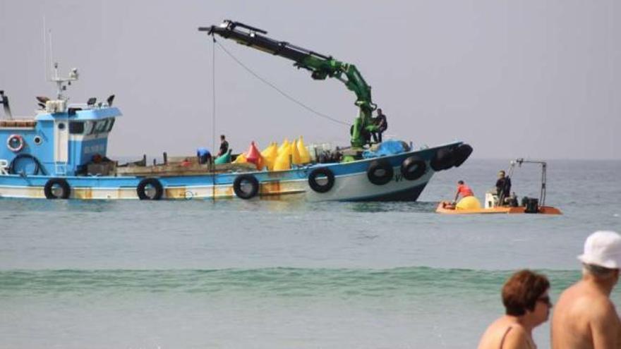 Trabajos de balizamiento de playas, que tratan de ayudar a los bañistas.  // Muñiz