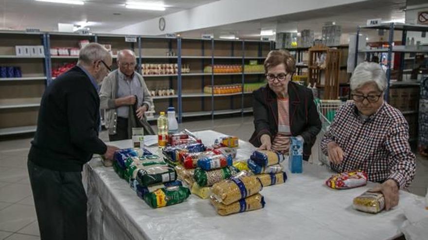 Voluntarios preparando los productos para entregarlos a los usuarios que acuden cada jueves al Economato de Cáritas Alcoy.