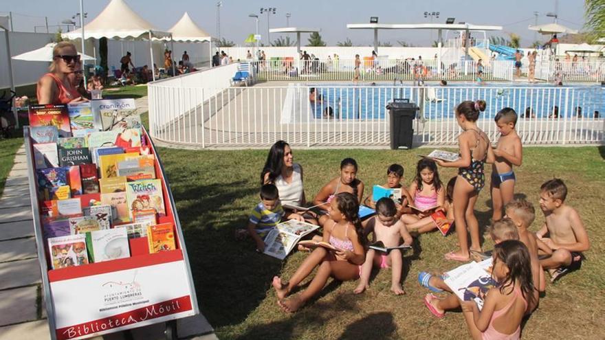 Los niños disfrutan de los libros en la piscina municipal.