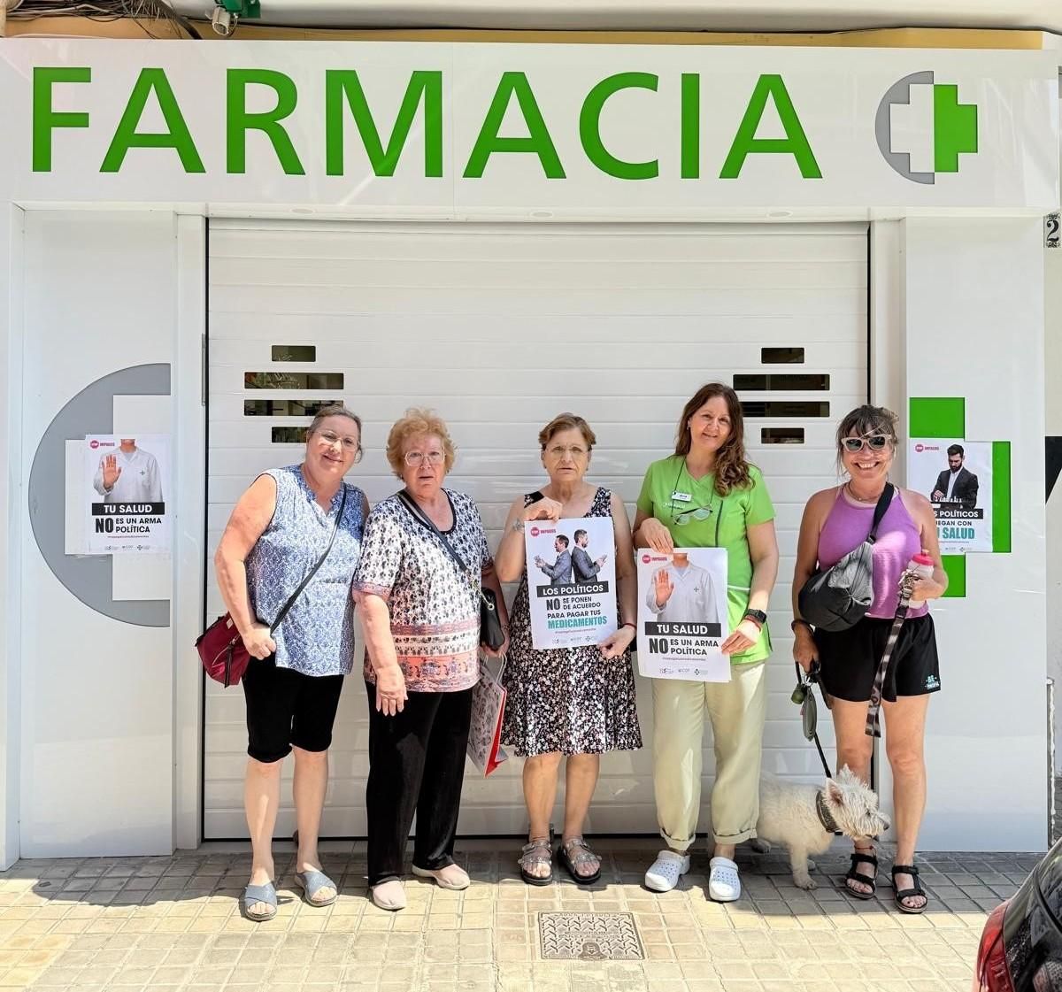 Pacientes ante la farmacia Vicente Brull durante la bajada de persianas del lunes.