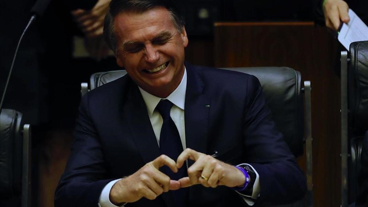 El presidente brasileño, Jair Bolsonaro, muestra un corazón con sus dedos durante su toma de posesión en el Parlamento.
