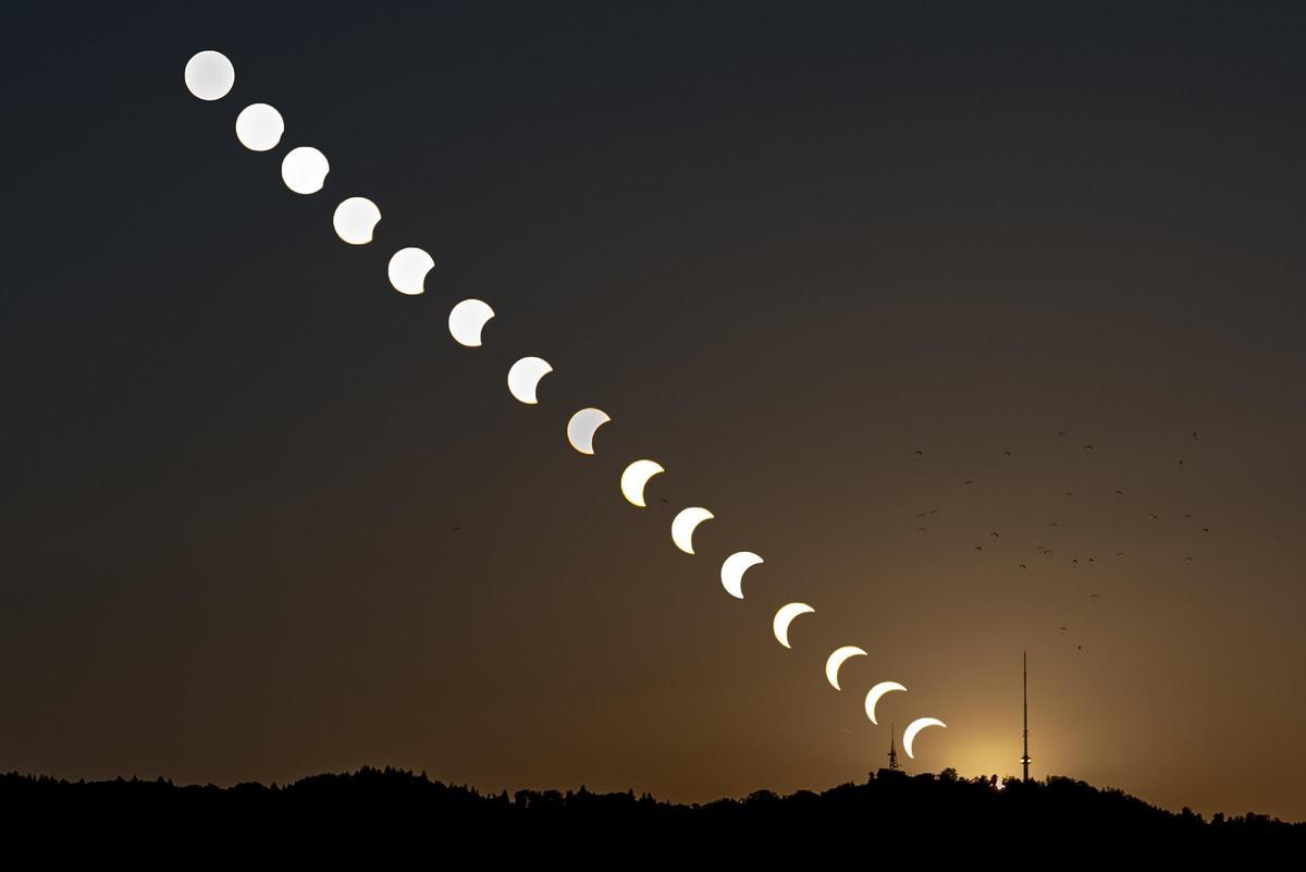 Composición creada a partir de 16 fotos individuales en la que se muestra cómo la Luna oscurece el Sol durante el eclipse en la montaña de Uetliberg en Zollikon, Suiza.