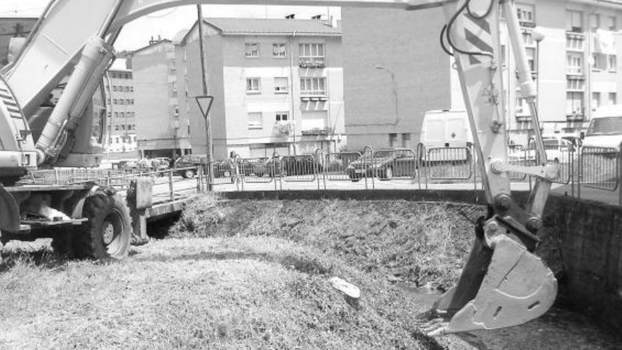 La máquina que participa en las tareas de limpieza, al lado del arroyo.