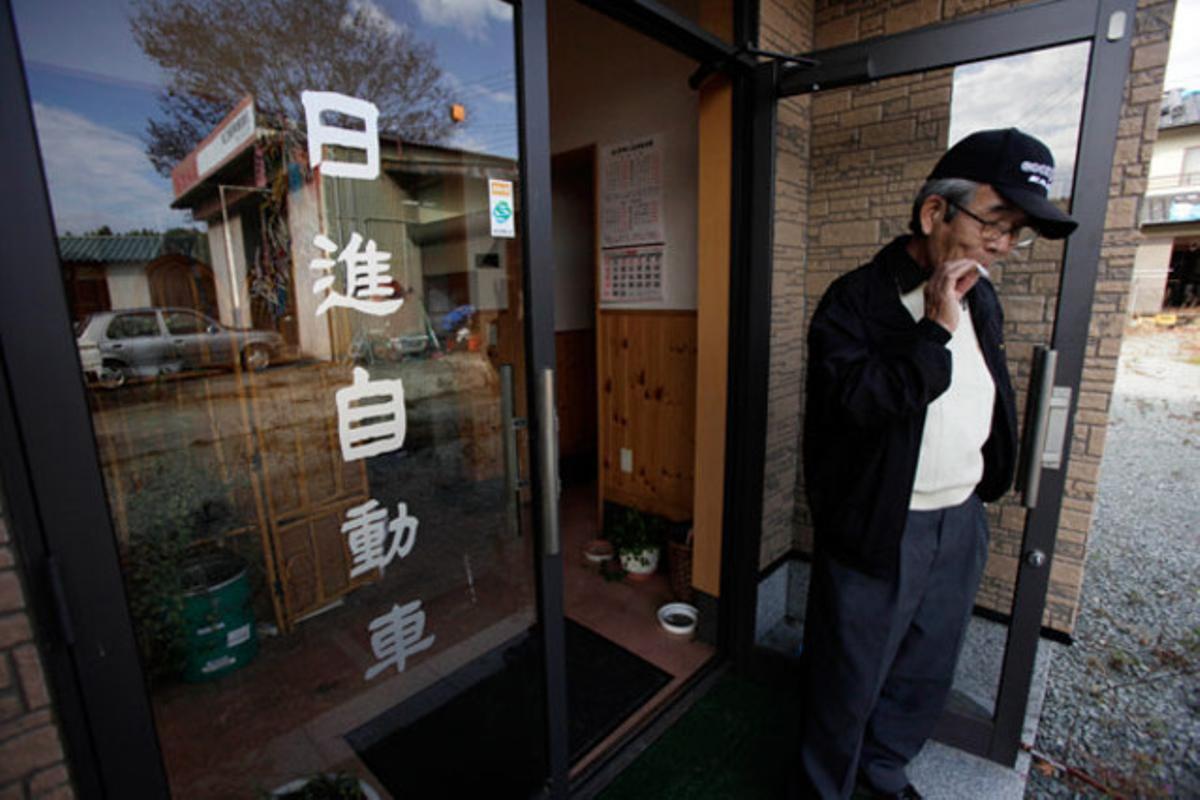Un home es fuma un cigarro després de visitar casa seva a la ciutat abandonada de Namie (Japó) després de l’accident nuclear de Fukushima.