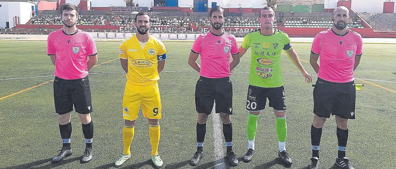 El trío arbitral junto a los capitanes de los equipos antes del inicio del encuentro de ayer.