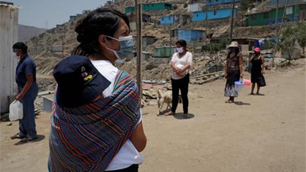 Unas personas esperan con ollas para recibir alimentos en el asentamiento humano de Buena Vista el 2 de febrero de 2021,