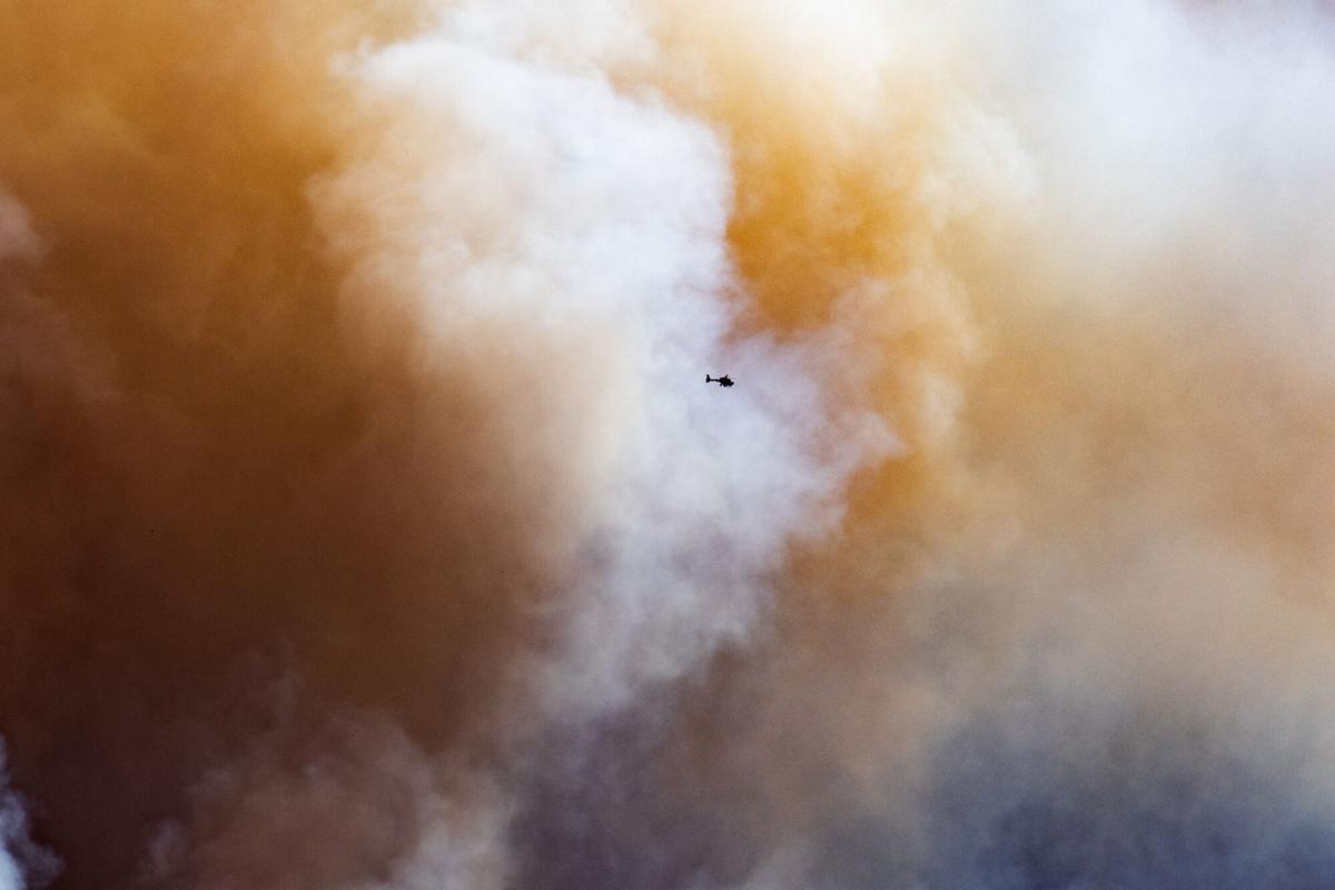 Un helicóptero sobrevuela en el humo del incendio, en La Bisbal d'Empordà, Girona, Catalunya
