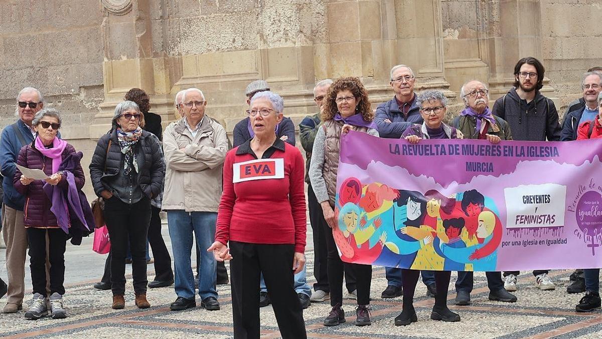 Un grupo de personas sostiene una pancarta feminista junto a la Catedral de Murcia