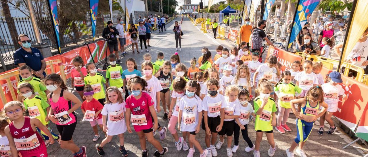 Jóvenes corredores, a punto de tomar la salida en una de las pruebas de ayer, con el Faro de Maspalomas detrás. | | JOSÉ FIR