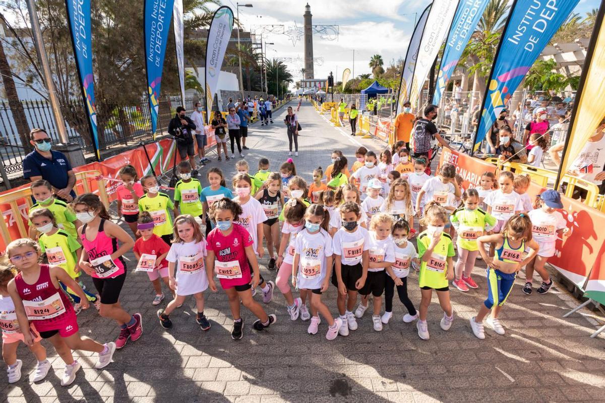 Jóvenes corredores, a punto de tomar la salida en una de las pruebas de ayer, con el Faro de Maspalomas detrás. | | JOSÉ FIR