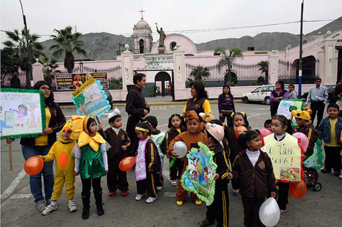 El sacerdot Mauro Vallejo (centre) i diversos escolars peruans participen en una desfilada pel Dia Mundial del Medi Ambient davant de l’edifici dels Descalços, un museu i convent franciscà amb més de 400 anys d’història situat a Lima.