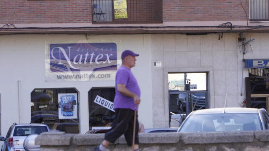 Un hombre pasa frente a una vivienda en venta en la capital.