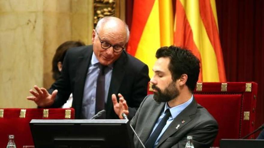 El president de la cambra, Roger Torrent, assegut, conversa amb el secretari general del Parlament, Xavier Muro